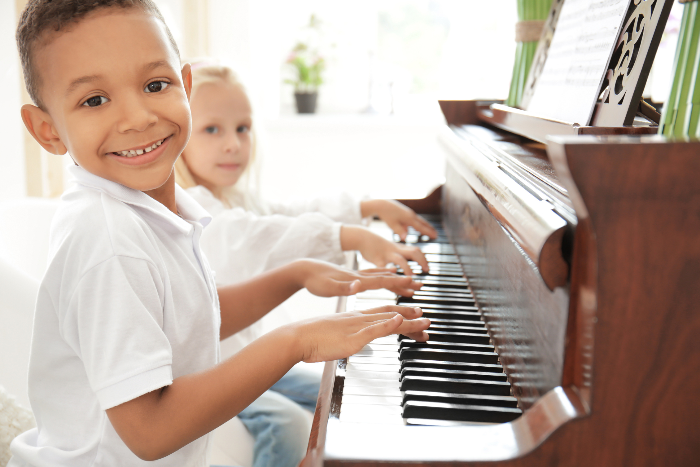 Boy with Little Girl Playing Piano Indoors